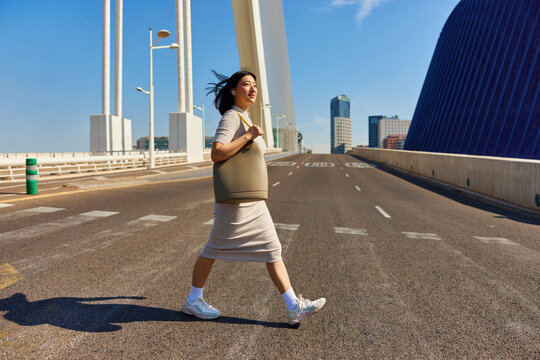 Asian woman crossing road on zebra