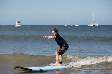 Boy surfing riding a wave into the beach in Costa Rica