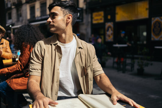 Young man browsing the bar menu deciding her order