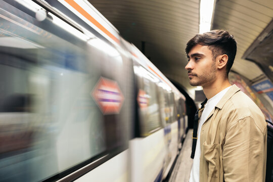 Young man waiting for the train standing on the subway platform