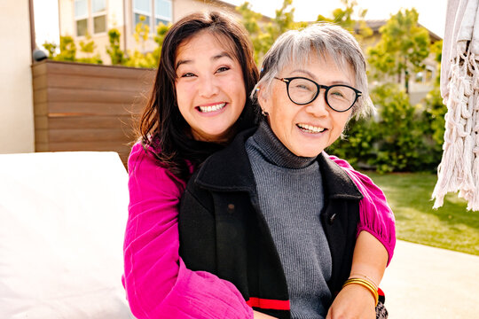 Happy and smiling asian adult daughter with her senior mother outdoors