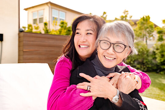 Happy and smiling asian adult daughter with her senior mother outdoors