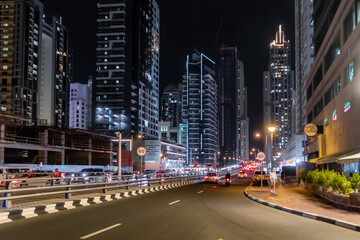 Dubai night street near the marina with illuminated skyscrapers in Dubai city, United Arab Emirates