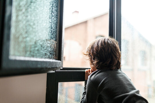 Kid At Home Watching The Rain