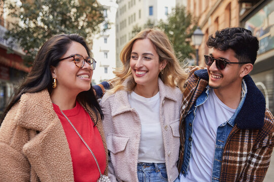 Group of friends walking together and engaged in conversation.