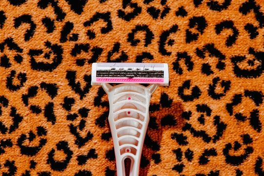 used pink razor on a beach towel