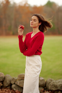 Young woman in red sweater and skirt on nature background