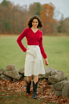 Young woman in red sweater and skirt on nature background