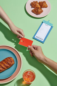 Customers give waiter mock up of credit bank card at table