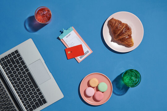 Two soft drinks, macarons and bread with laptop, ceciept and