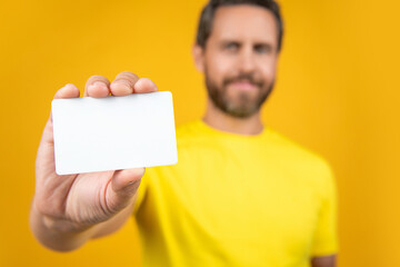 selective focus photo of blank credit card with laptop. blank credit card isolated on yellow.