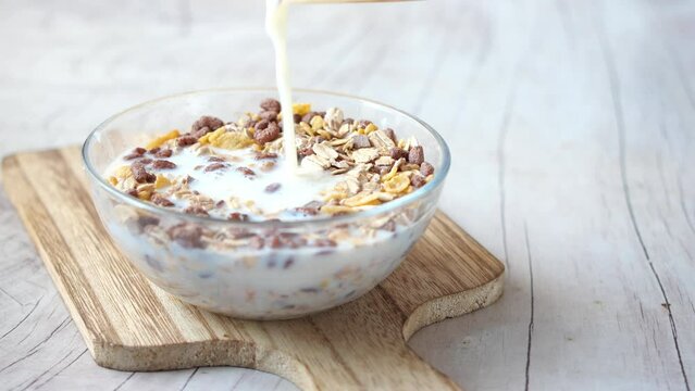 pouring milk into the breakfast cereal 