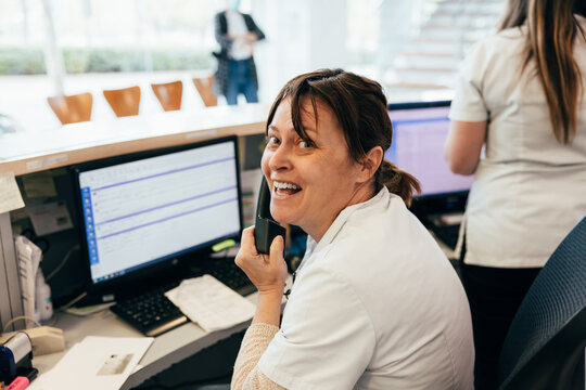 Happy nurse talking on telephone during work