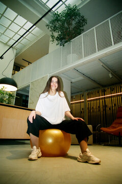 Film photo Young business woman sitting on a fitball in the office