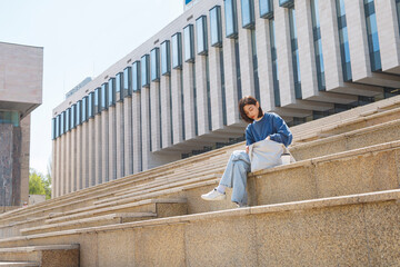 Young student looking for things in bag