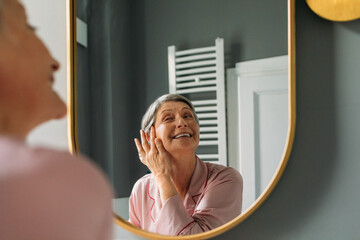 Senior Woman Applying Oil Serum on Face