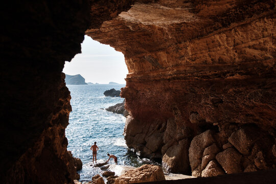 Anonymous men in a cave on the beach