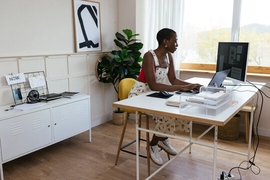 Woman working on laptop at creative workspace