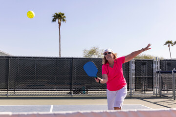 Senior Citizen fitness Pickleball player looks to swing at ball 