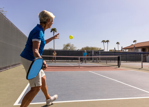 Senior Citizen Pickleball player serve  swing at ball active lifestyle