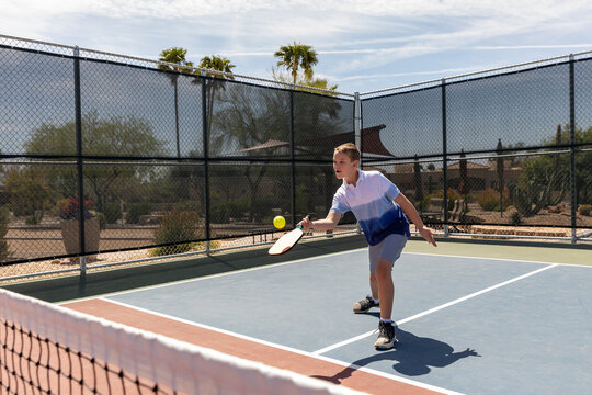 Young boy Pickleball player looks to swing at ball 