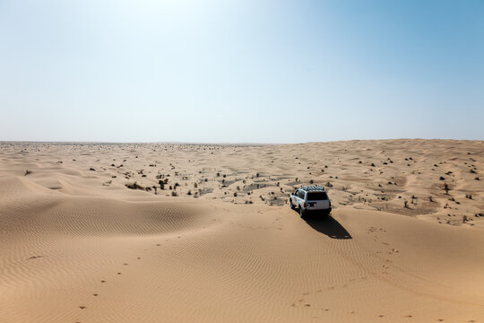 Wide view of an off-road car in the vastness of the desert