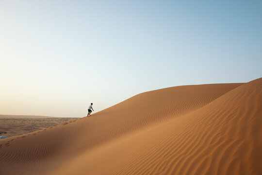 Man walking through the dunes of the Sahara desert