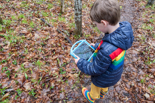 Child using a tablet to identify plant species