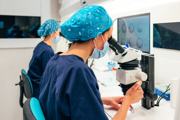 Female biologists doing IVF with microscope in lab