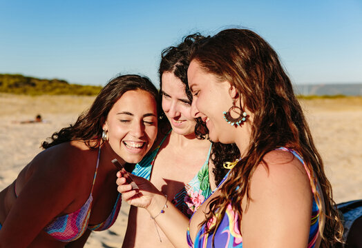 Friends in bikinis looking at polaroid photo