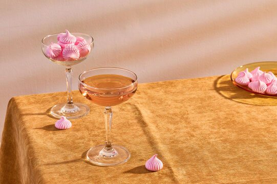 Glasses of wine and pink meringues