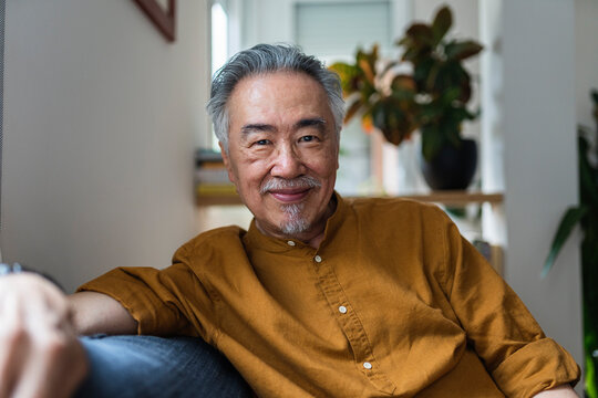 Serene senior in positivity attitude on couch.