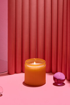 Soy wax candle in glass on scene with geometrical forms