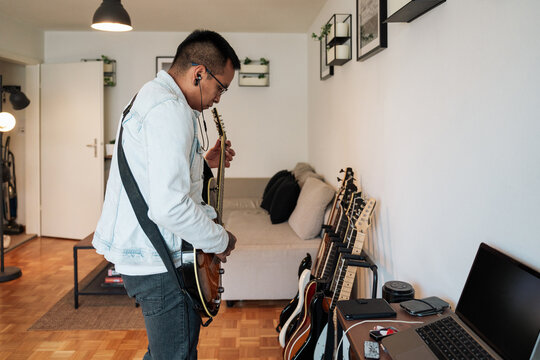 Amateur guitarrist practicing at home