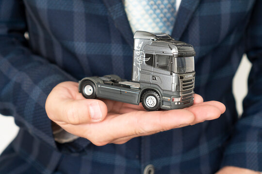 close-up Businessman's Hand Protecting Car On The Toy Truck. Truck insurance concept. The inscription on the poster is insurance. Moldova, Chisinau,  May 21, 2023.