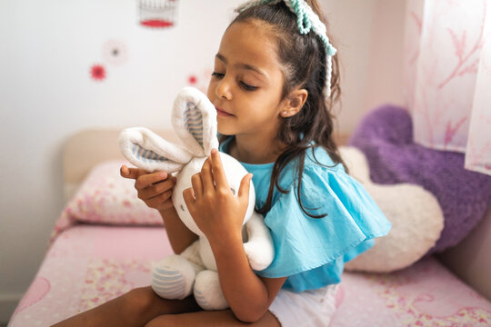 girl playing with stuffed toy at home