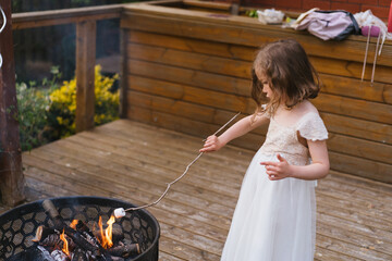 Little girl roasting a marshmallow on fire