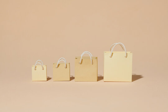 Set with kraft paper shopping bags on beige background