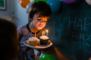 Boy blows out candles for his fourth birthday