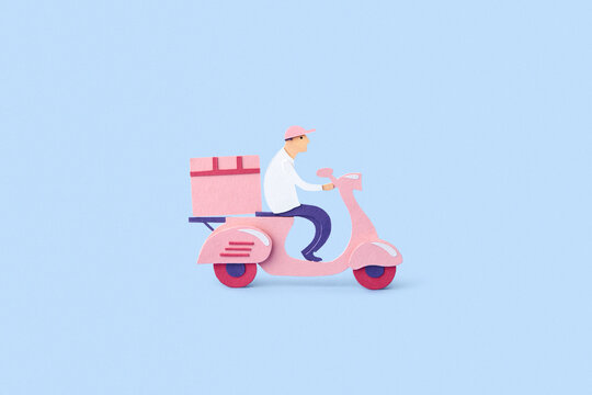 Papercraft delivery courier on scooter.