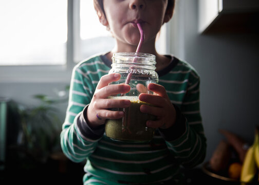 Boy drinks green smoothie
