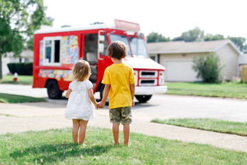 View from behind of siblings holding hands