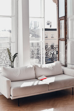 Book lies on a sofa in a sunny room
