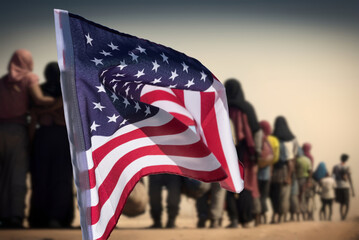 United States flag and a group of migrants at the border
