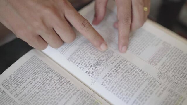 Hand of man reading the Bible Spiritual concepts by studying the Holy Scriptures together.