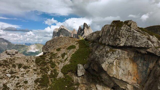 Aerial view over cliffs, revealing the Seceda ridge, summer day in Dolomites, Italy