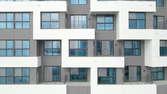 Facade of a modern gray building of residential complex close-up, urban geometry.