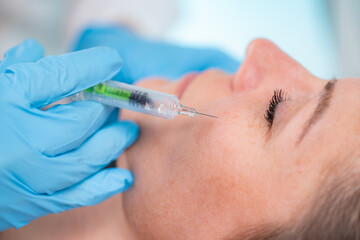 Hyaluronic acid treatment. Dermatologist plumping up cheeks with hyaluronic acid injection filler