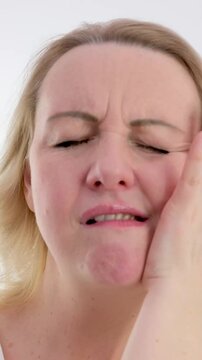 Young caucasian woman touch her cheek having severe toothache sitting on couch at home, unhealthy brunette girl 20s suffers from painful sensations need dental service, medical insurance