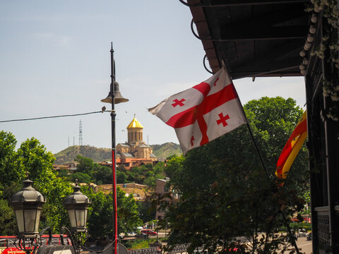 Panorama of Tbilisi, Georgia, with a stunning view of the Georgian flag and a church.